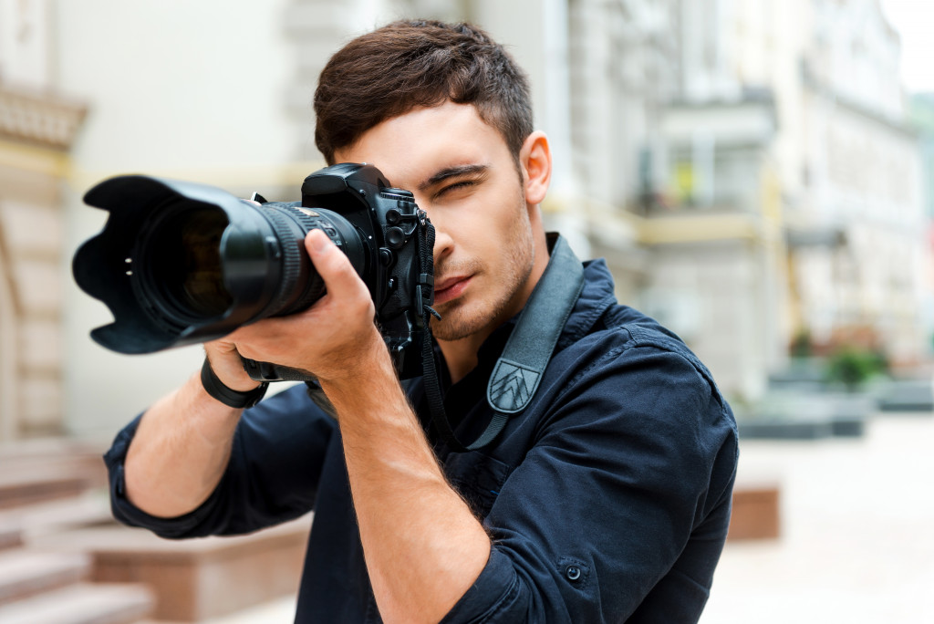 Confident young man photographing something