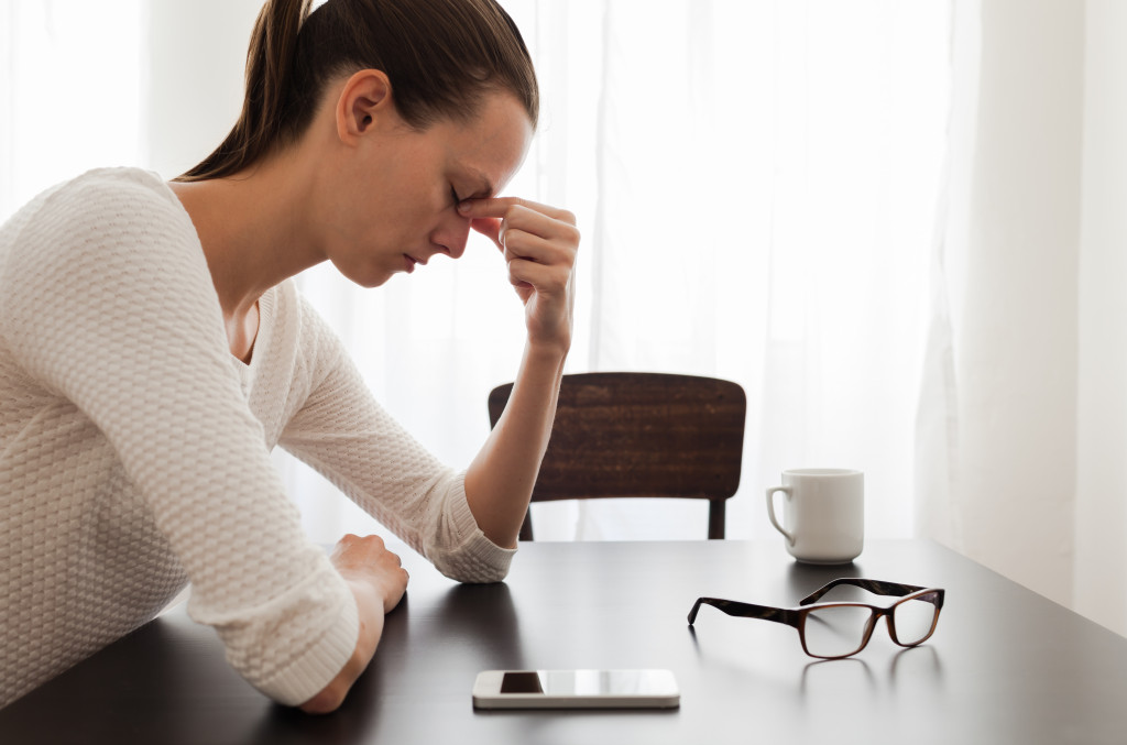 Stressed and worried businesswoman with her mobile phone on the table