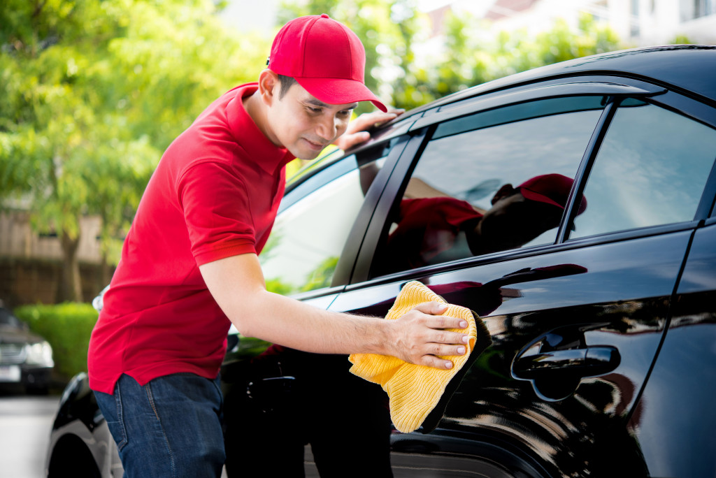 worker cleaning a car