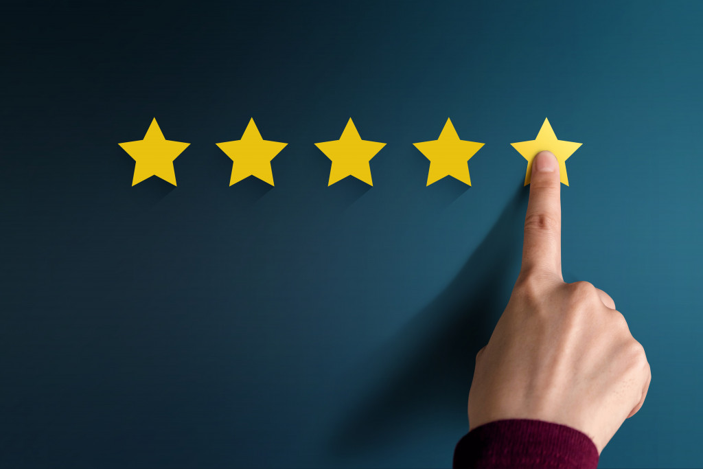 person's finger touching the fifth star representing good reviews